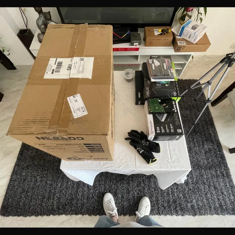Mesa de trabajo con componentes, guantes y herramientas para ensamblar un PC gamer